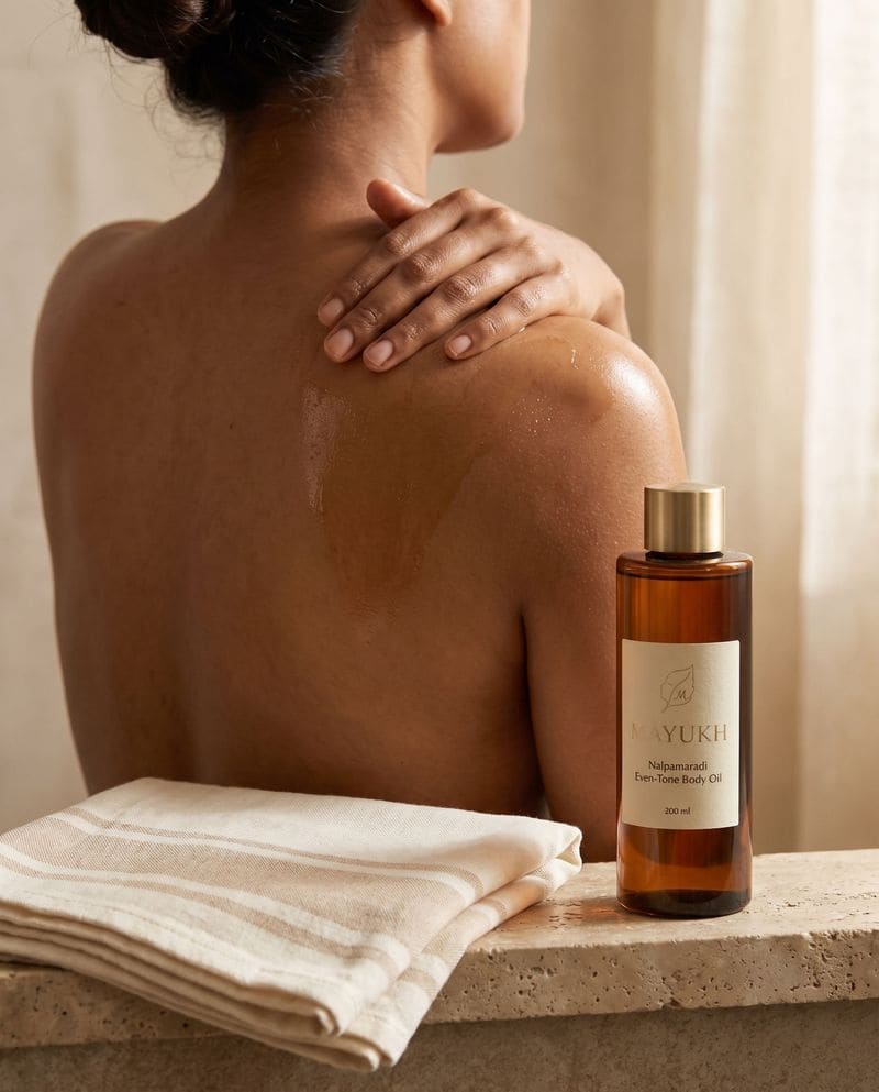 Even-tone body oil smoothed over the shoulder after a bath